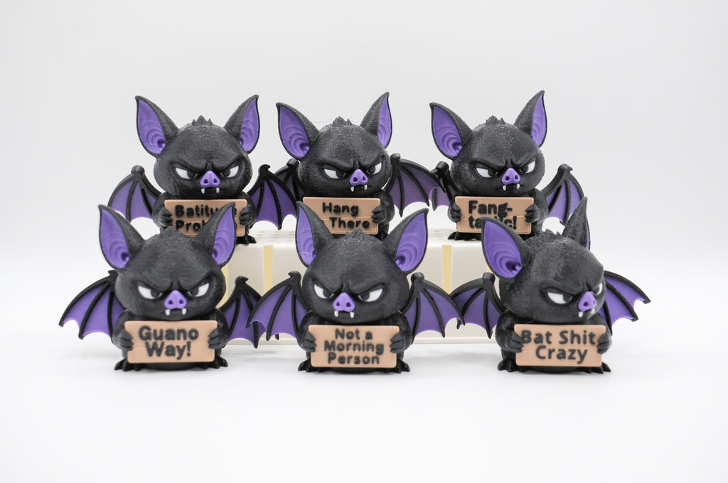 Group of bat figures holding six humorous signs