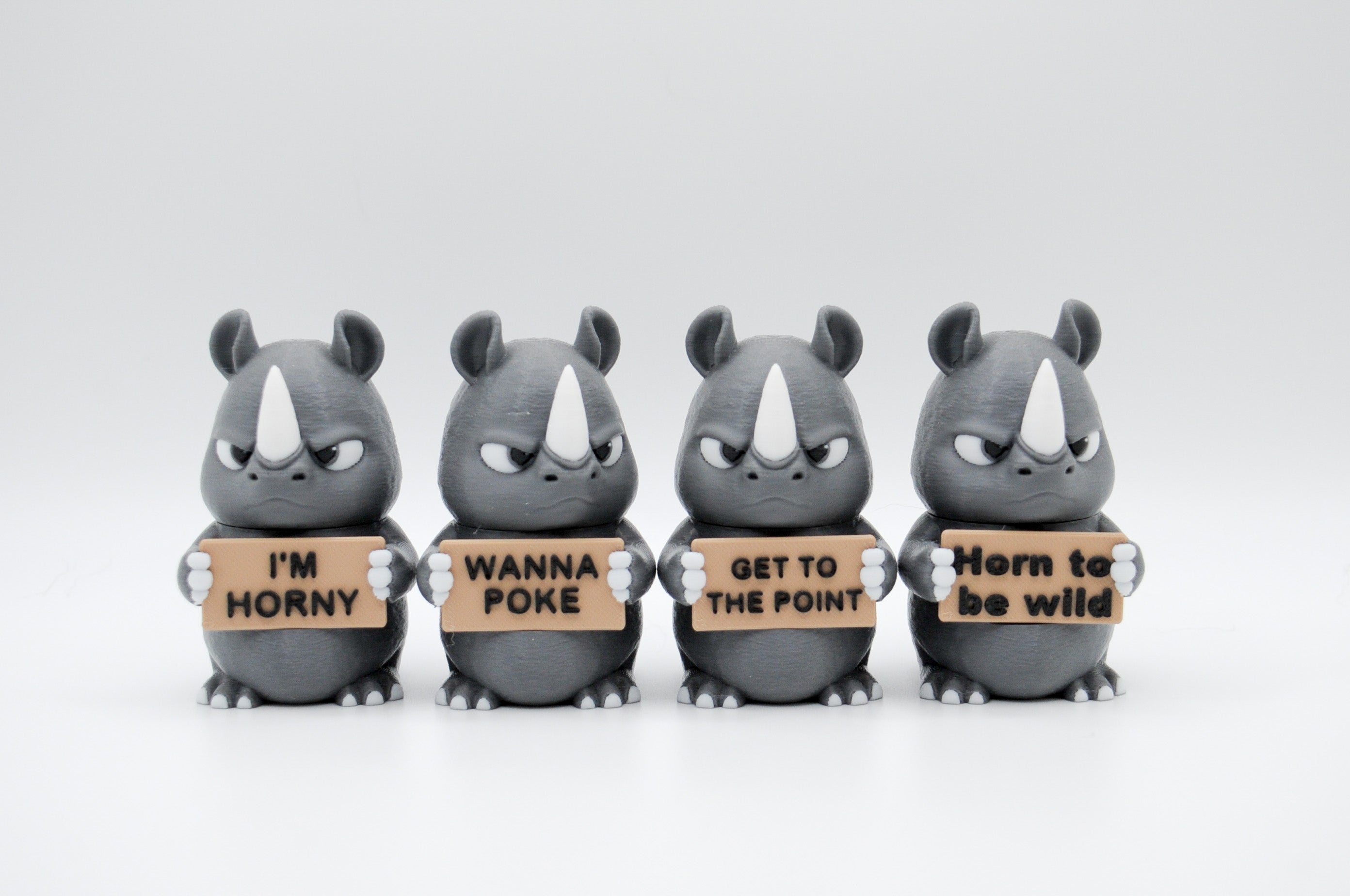 Group of rhinoceros figures holding four humorous signs