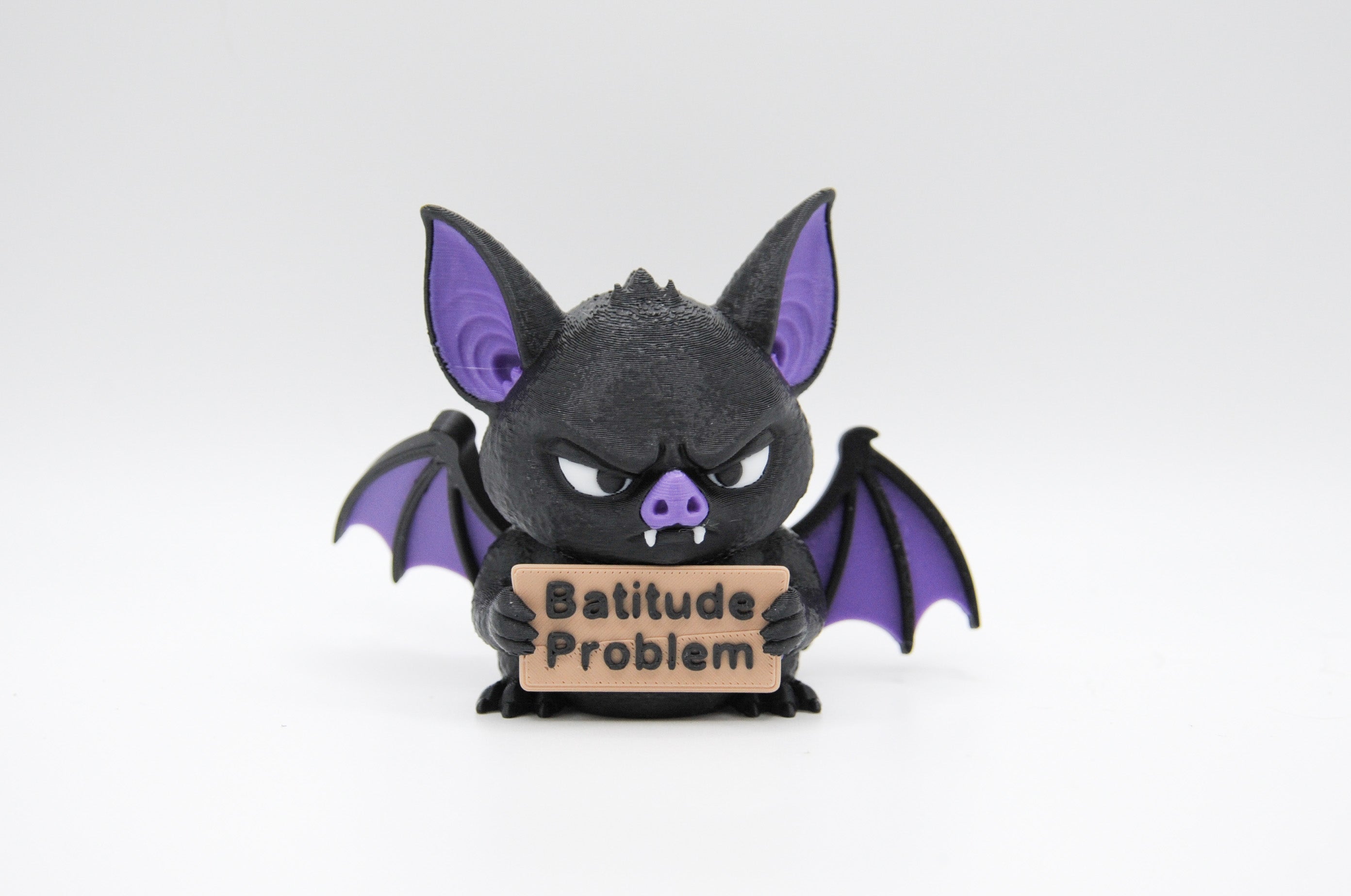 Bat holding a Batitude Problem sign