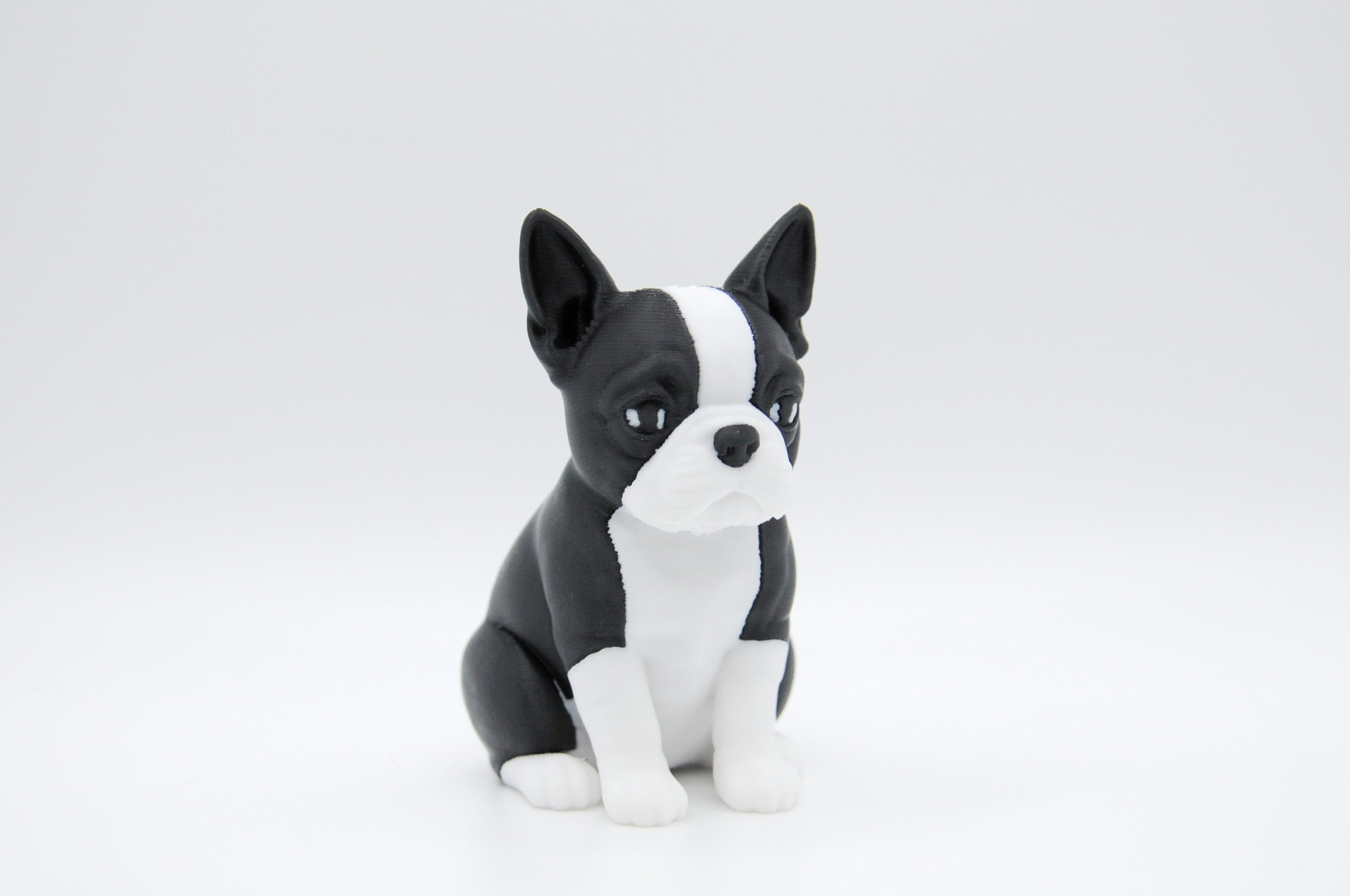 Black and white Boston terrier figure seated upright