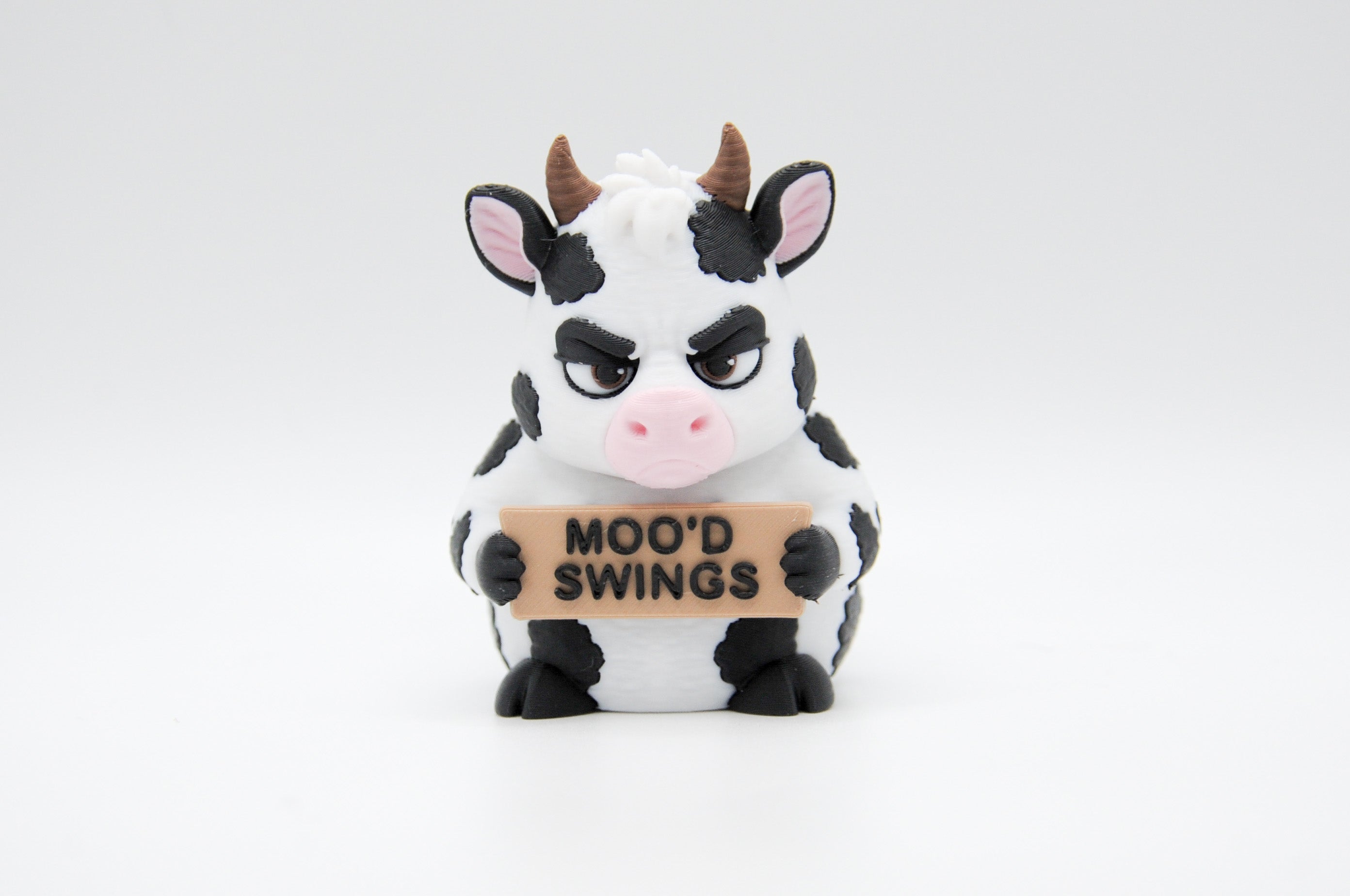 Cow holding a Moo'd Swings sign