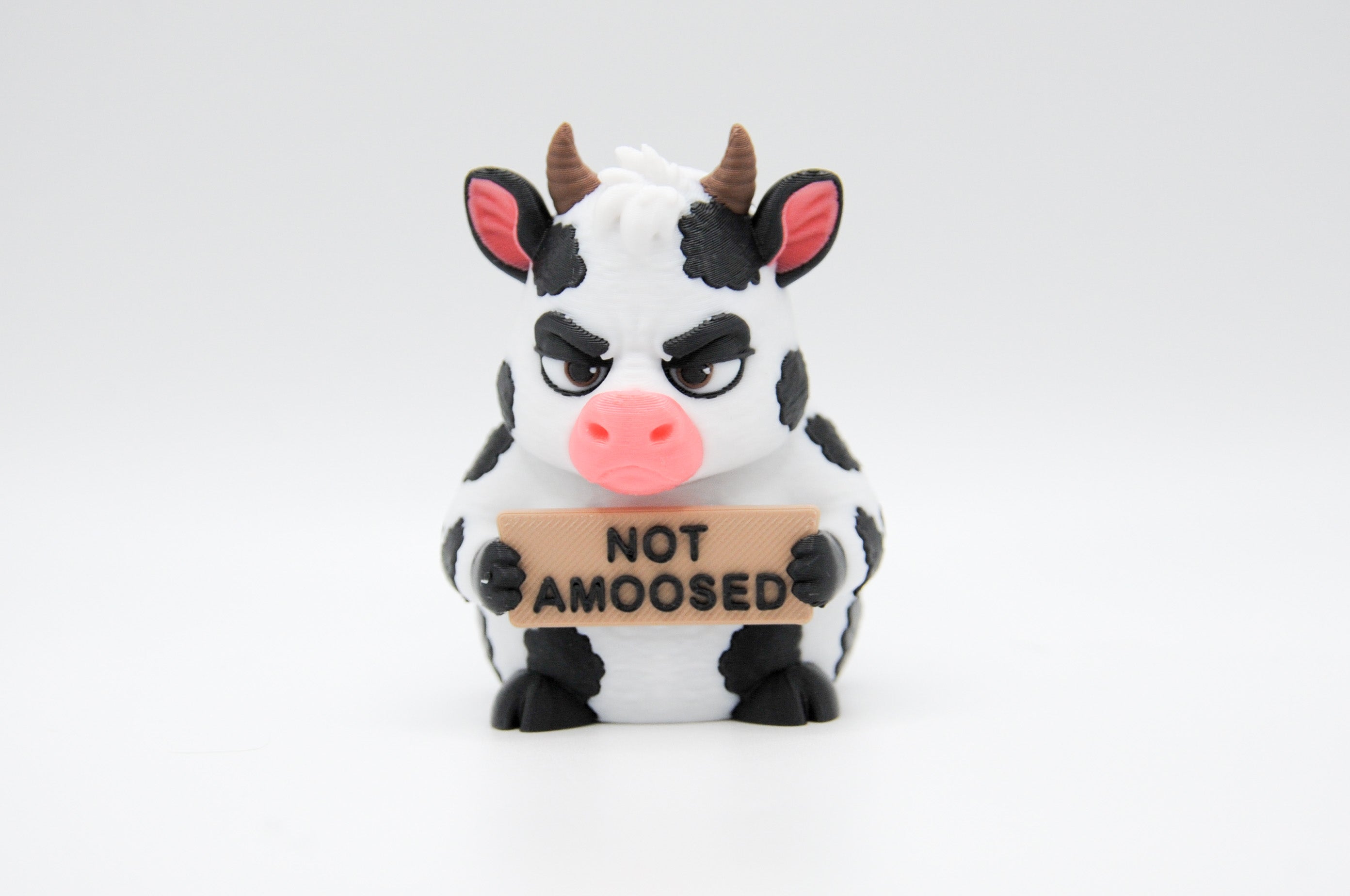 Cow holding a Not Amoosed sign