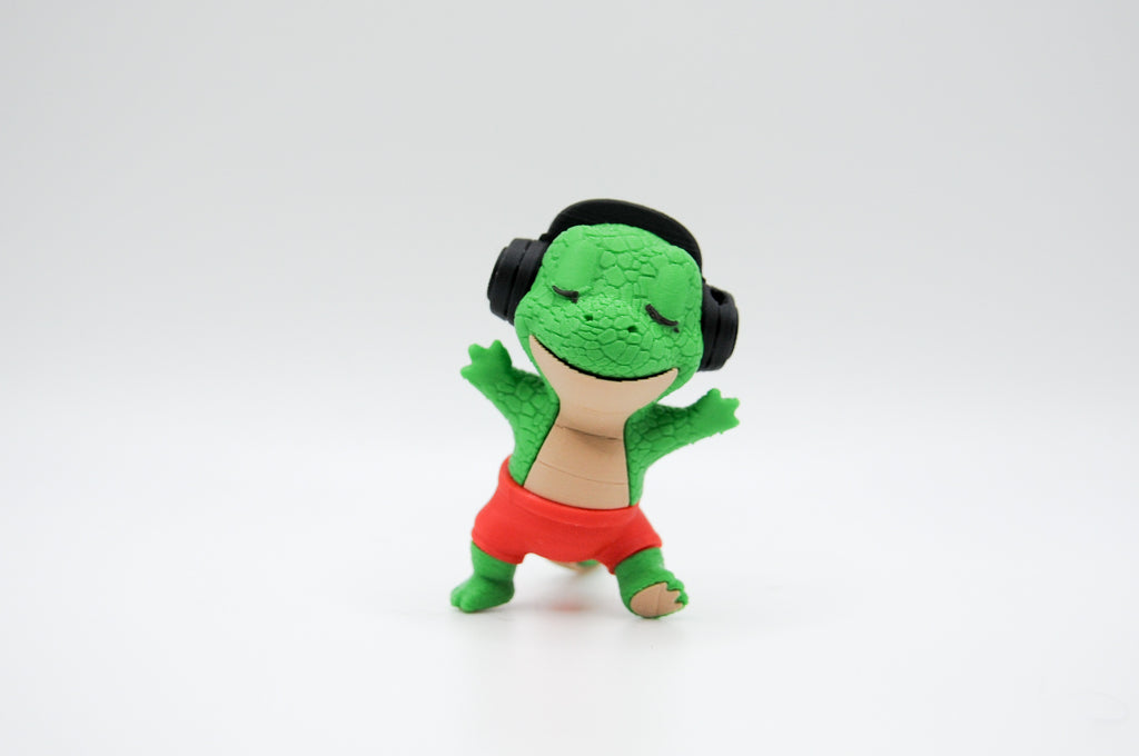 Standing green frog figure wearing black headphones