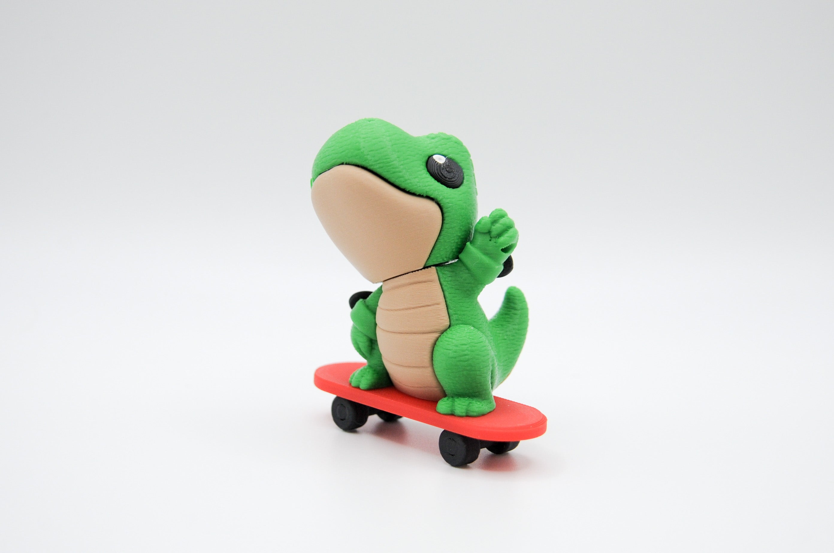 Green frog figure riding a red skateboard