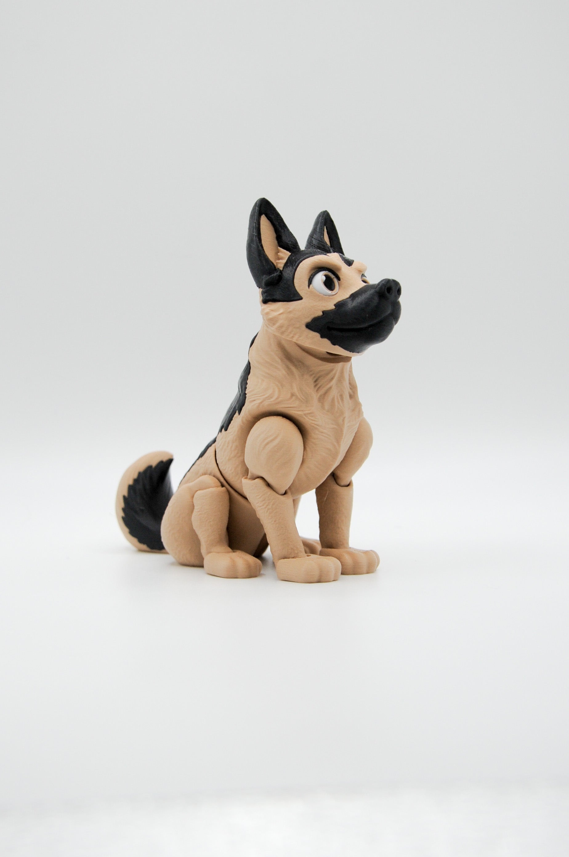 Portrait view of a seated tan and black German shepherd figure