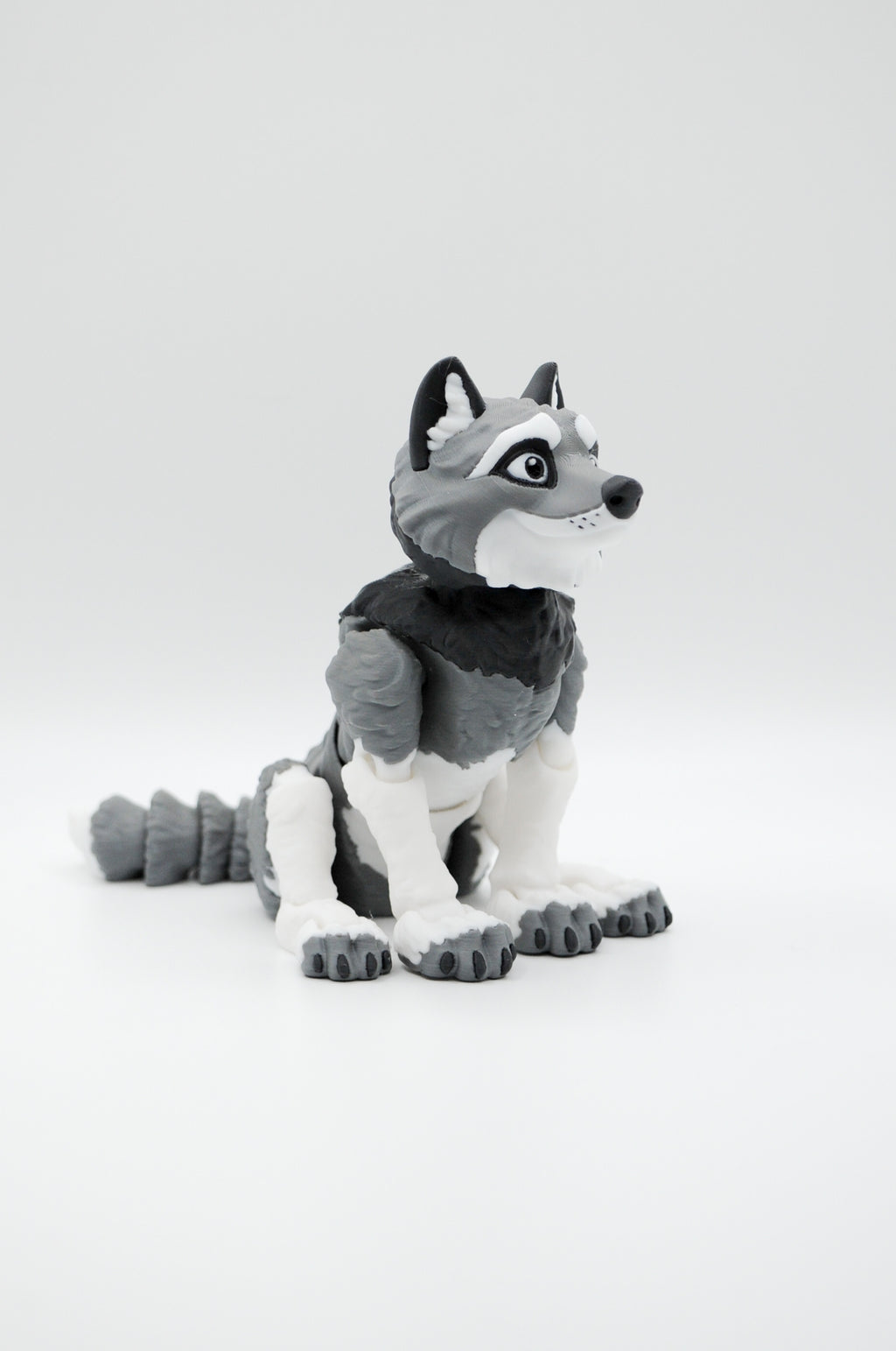Portrait view of a seated gray and white wolf figure