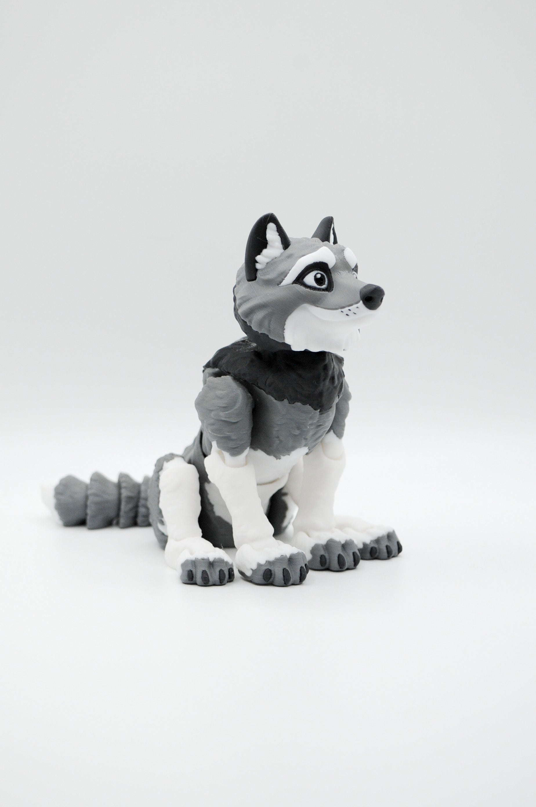 Portrait view of a seated gray and white wolf figure