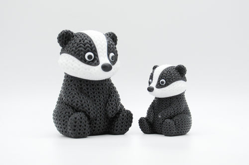Black, white, and gray knitted-style badger figures in large and small sizes