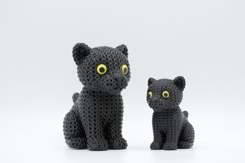 Black knitted-style cat figures with yellow-green eyes in large and small sizes