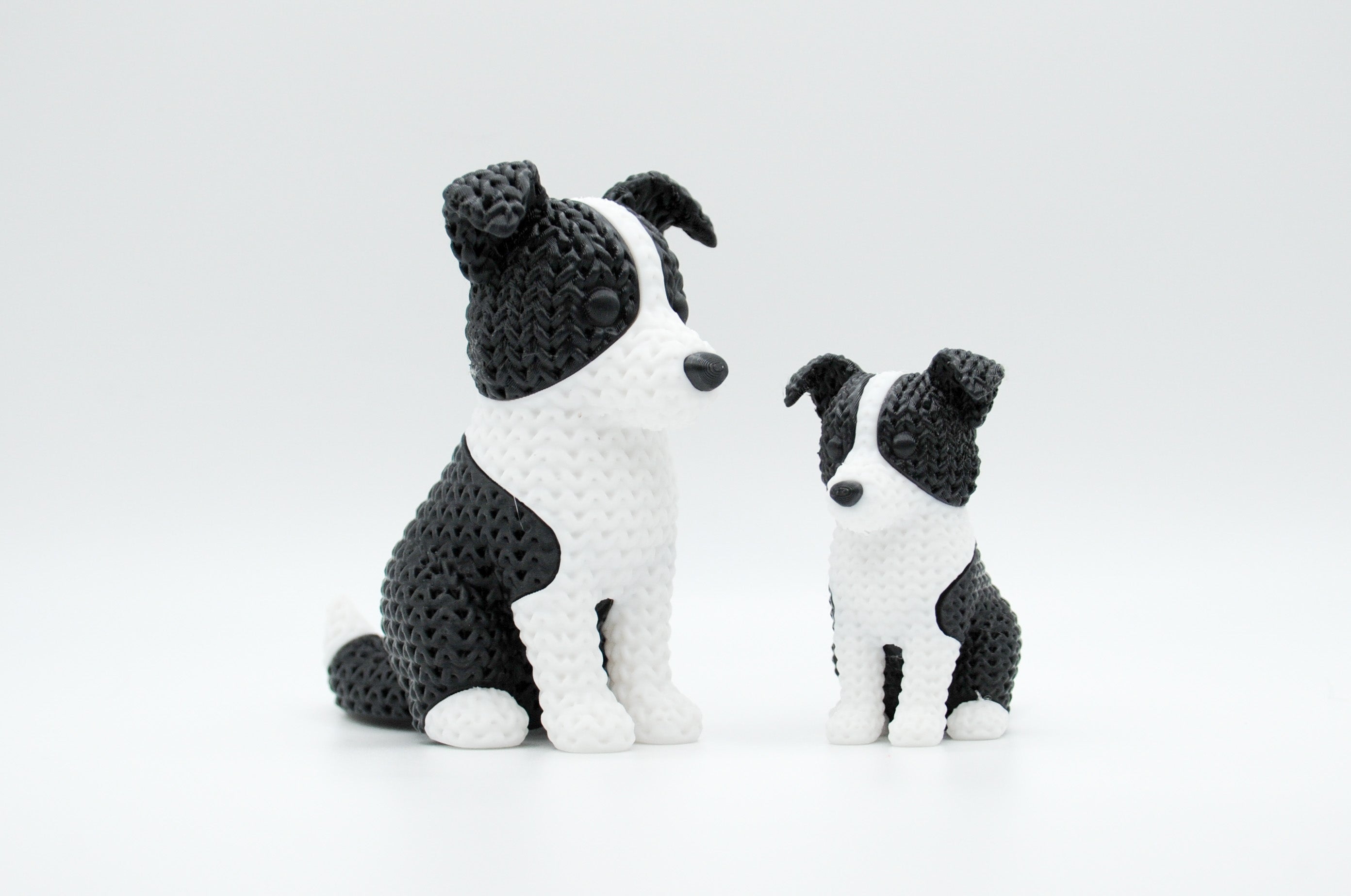 Black and white knitted-style border collie figures in large and small sizes