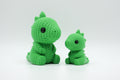 Bright green knitted-style dinosaur figures in large and small sizes