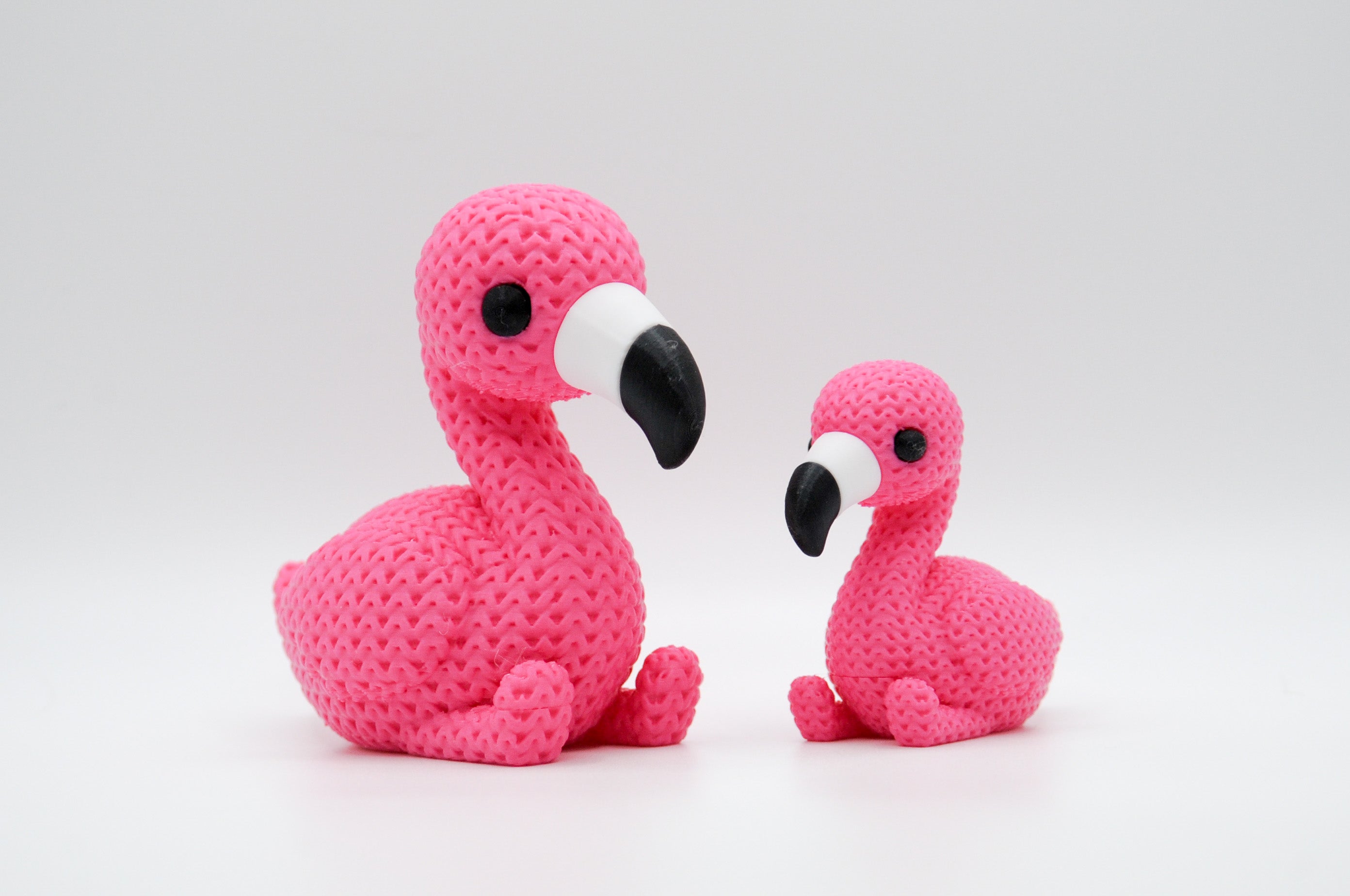 Pink knitted-style flamingo figures in large and small sizes