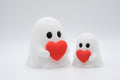 White knitted-style ghost figures holding red hearts in large and small sizes