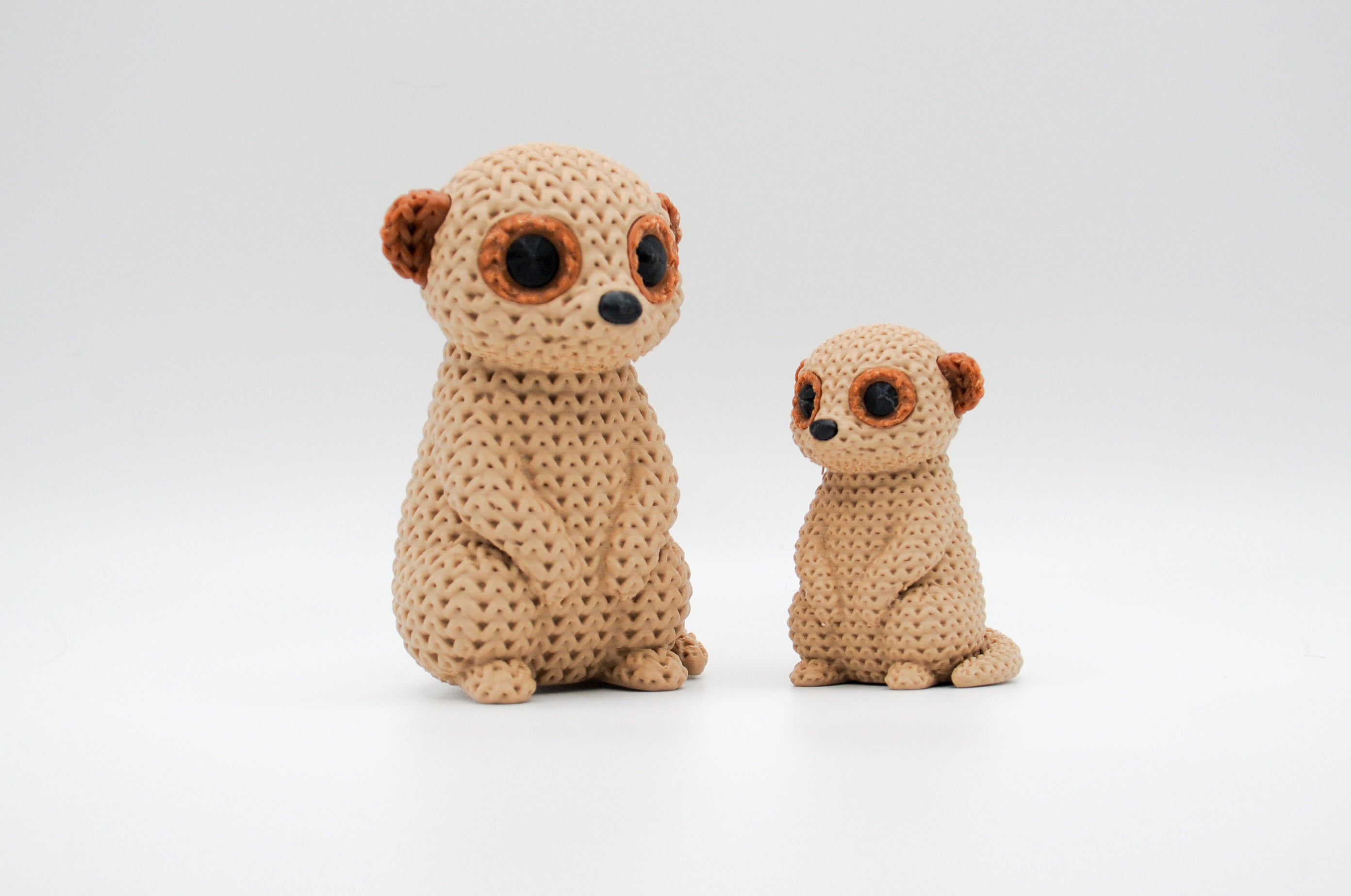 Tan knitted-style meerkat figures in large and small sizes