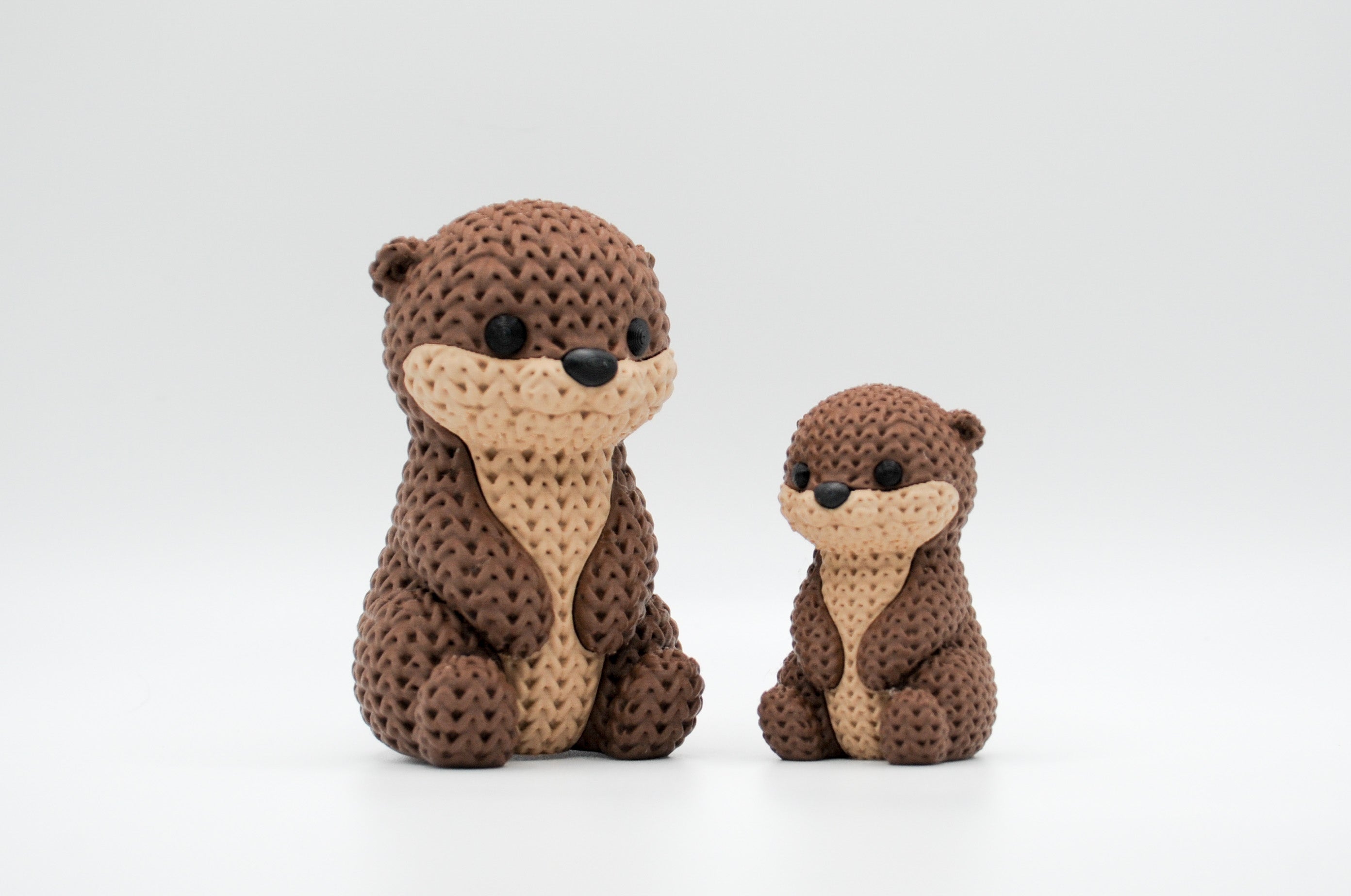 Brown knitted-style otter figures in large and small sizes