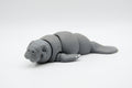 Gray manatee figure resting in a horizontal pose