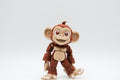 Brown smiling monkey figure with oversized ears and curled tail