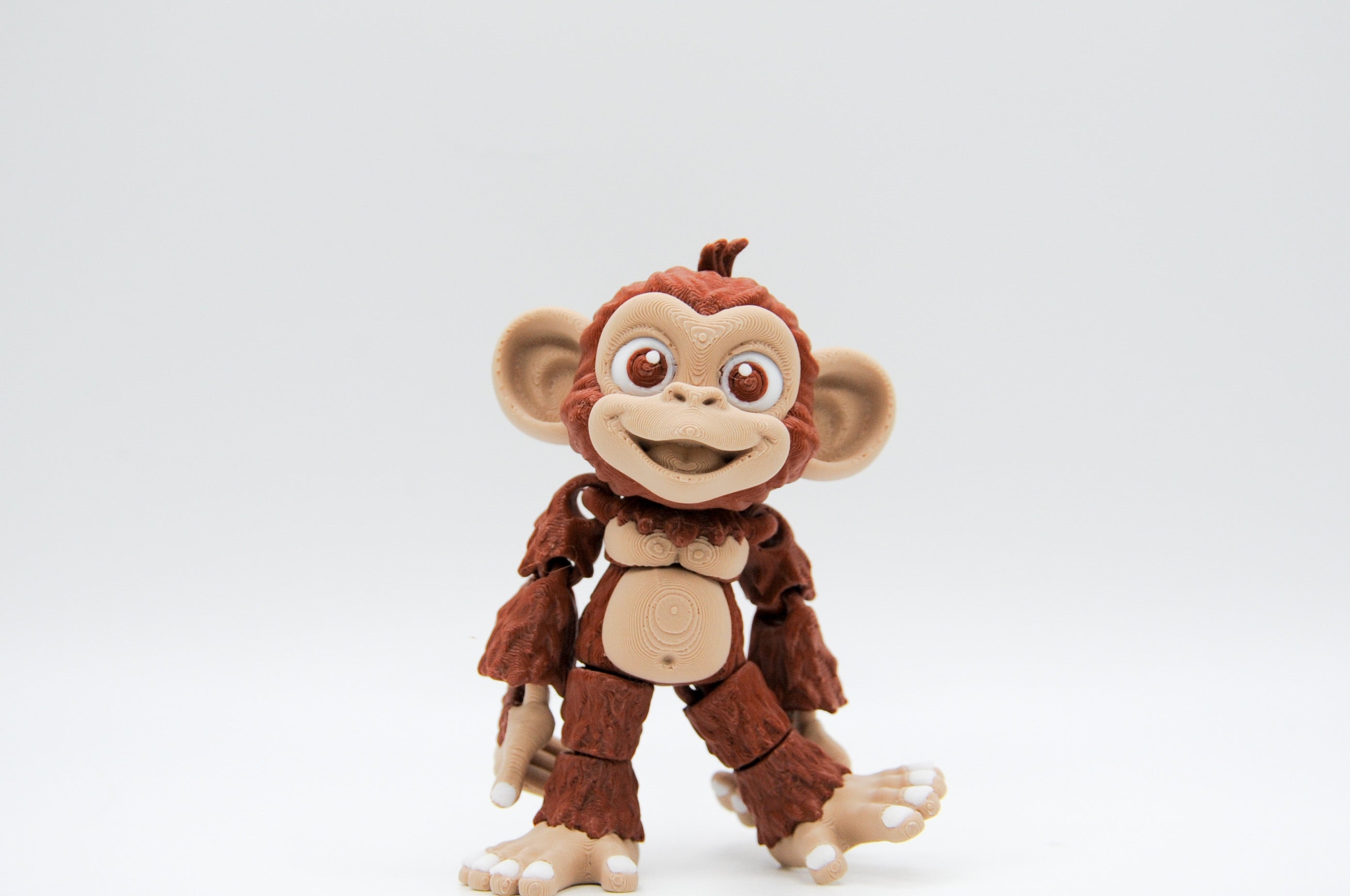 Brown smiling monkey figure with oversized ears and curled tail