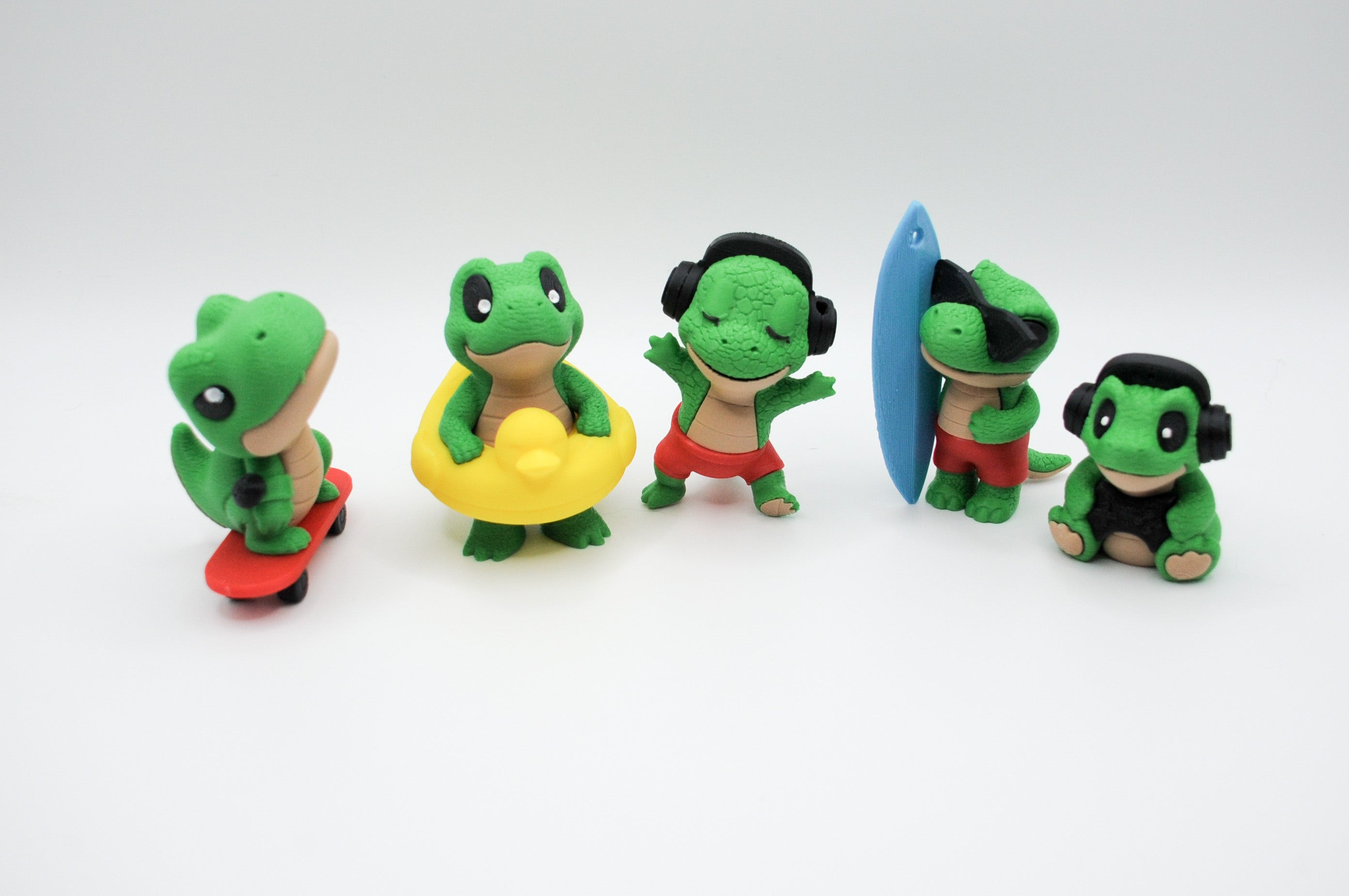 Group of five green frog figures with playful accessories
