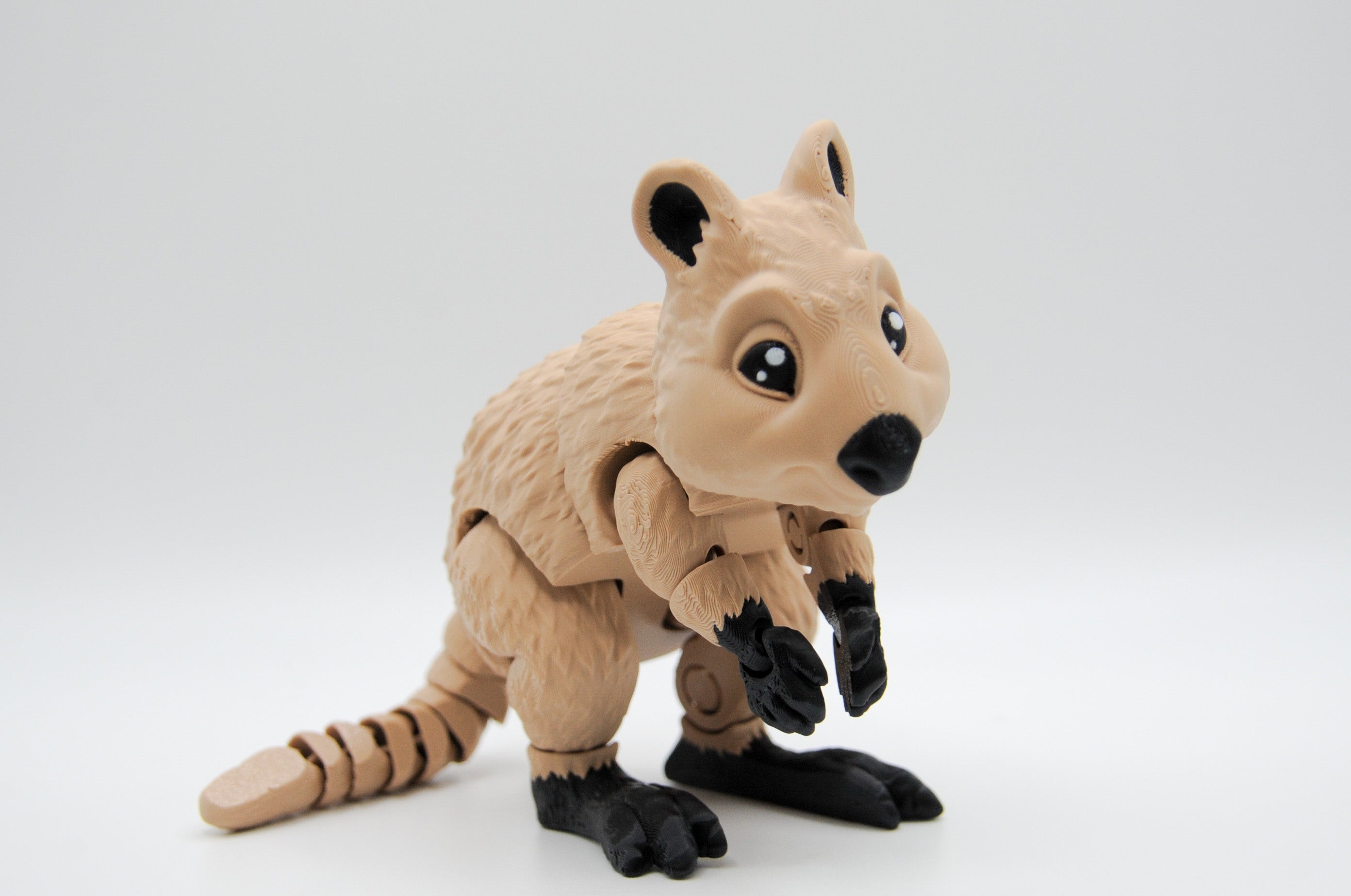 Tan quokka figure leaning forward with long tail extended