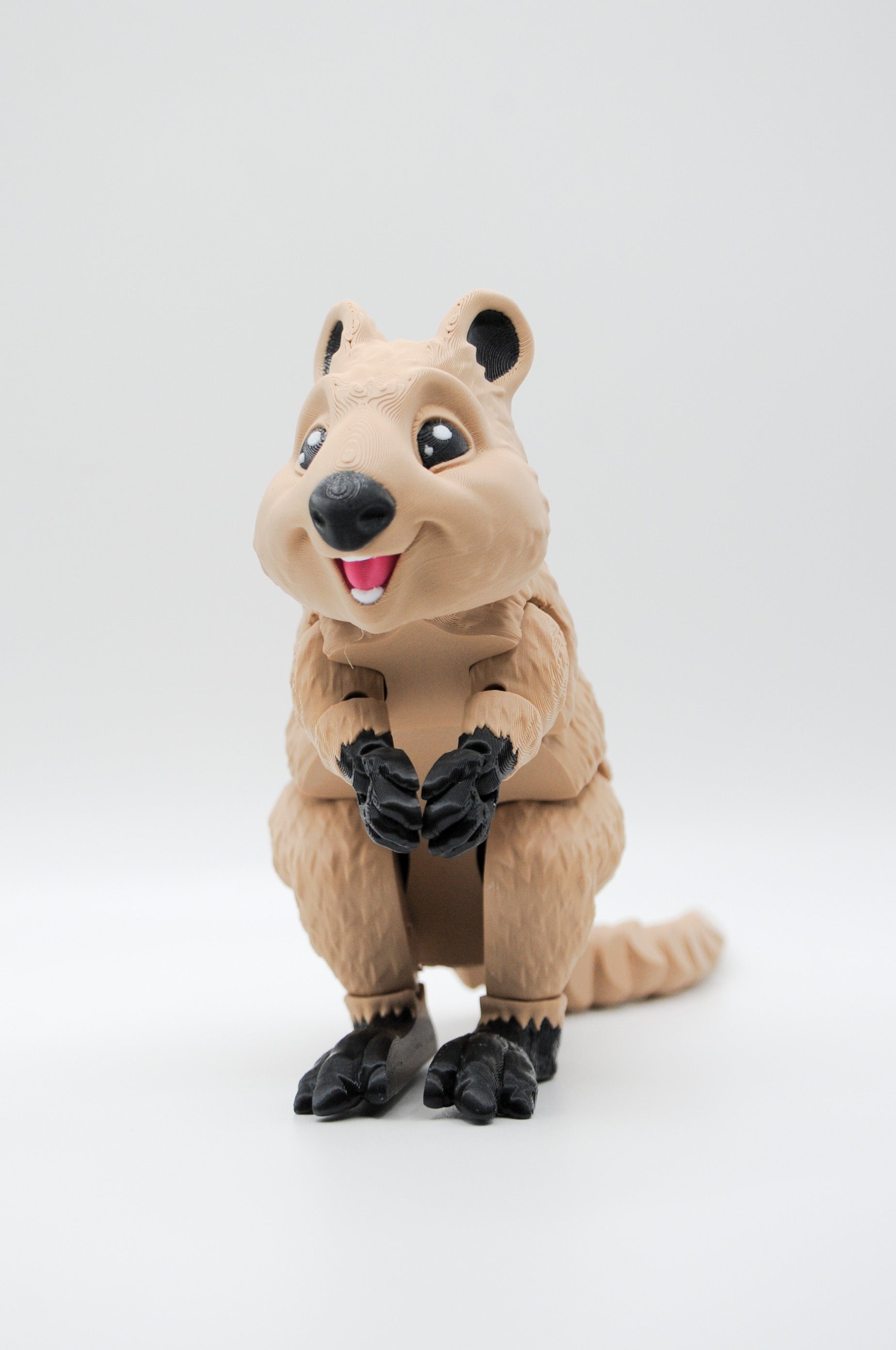 Portrait view of a smiling upright tan quokka figure