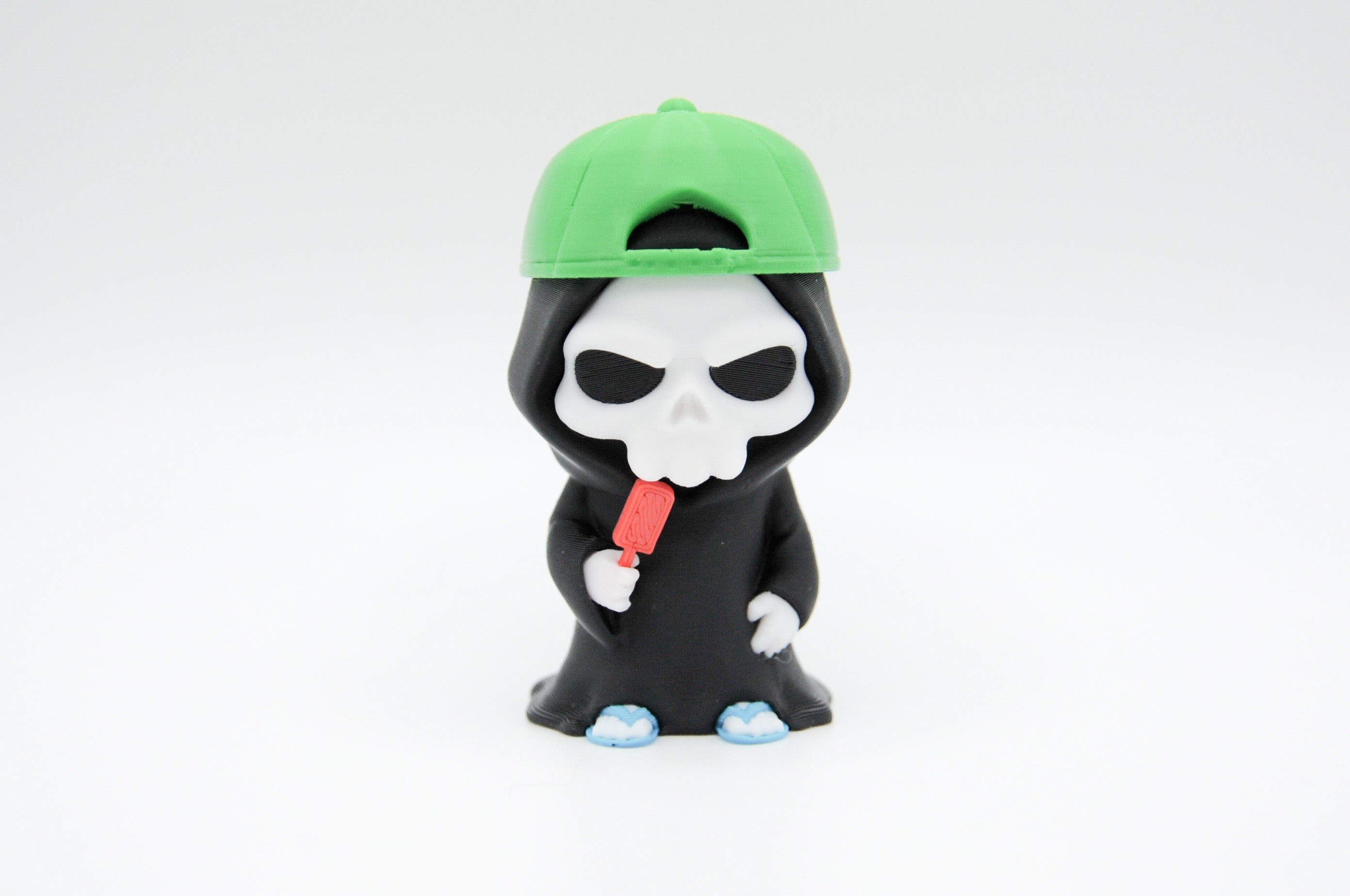 Hooded reaper figure wearing a green cap and holding a red popsicle