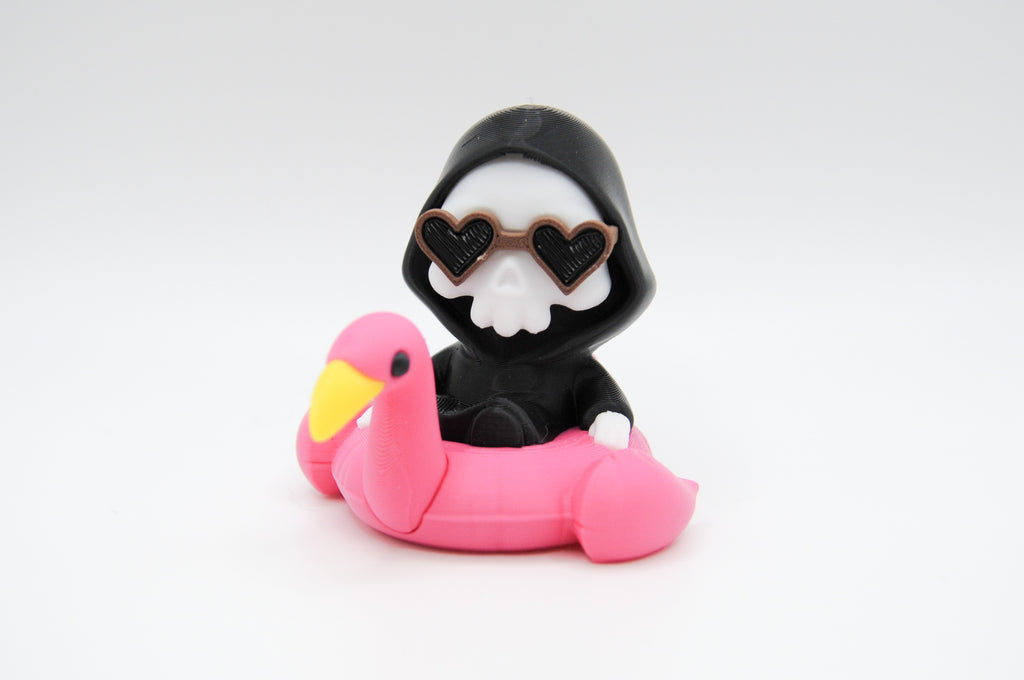 Hooded reaper figure wearing heart sunglasses in a pink flamingo float