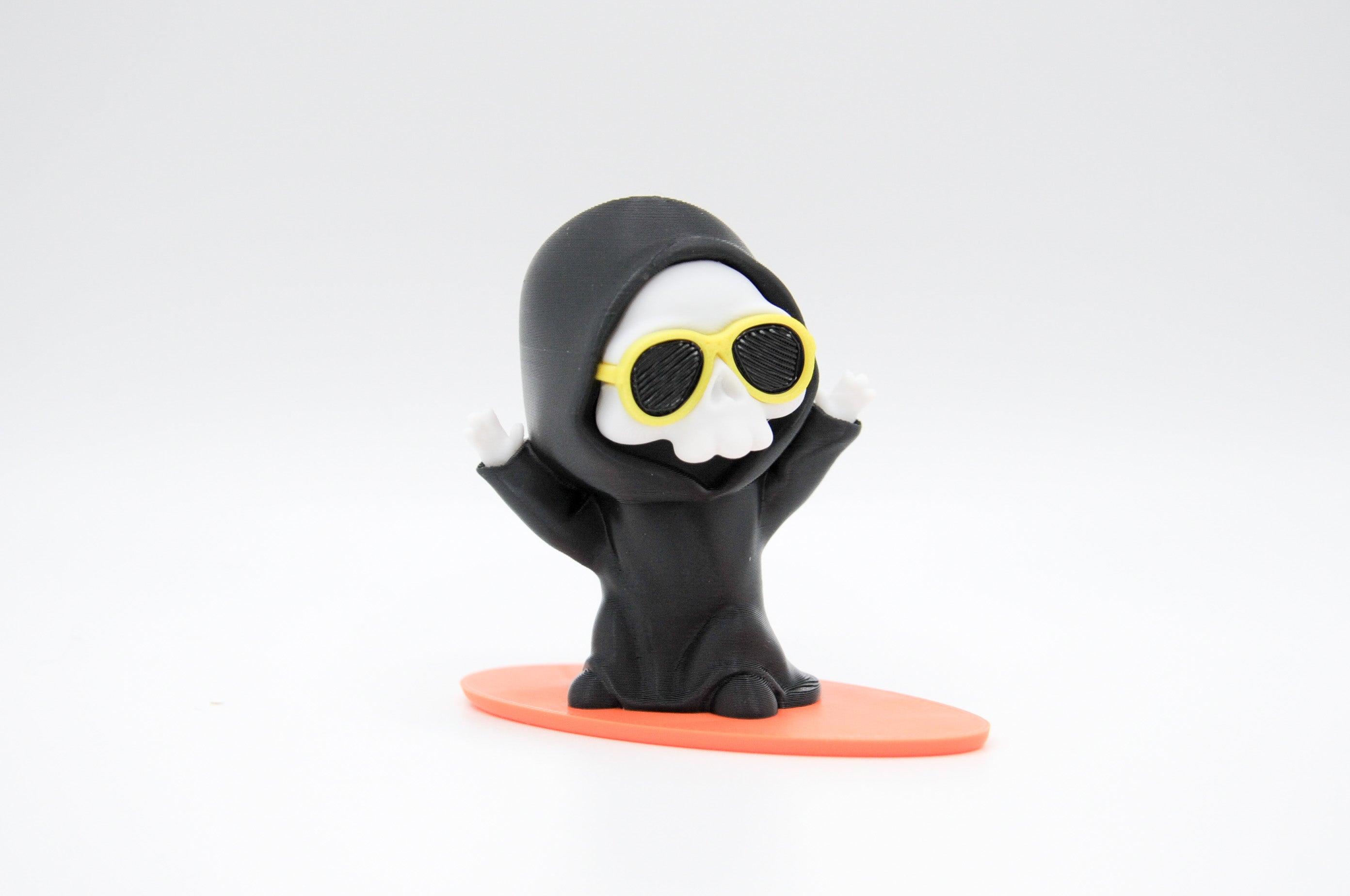 Hooded reaper figure wearing yellow sunglasses on a surfboard