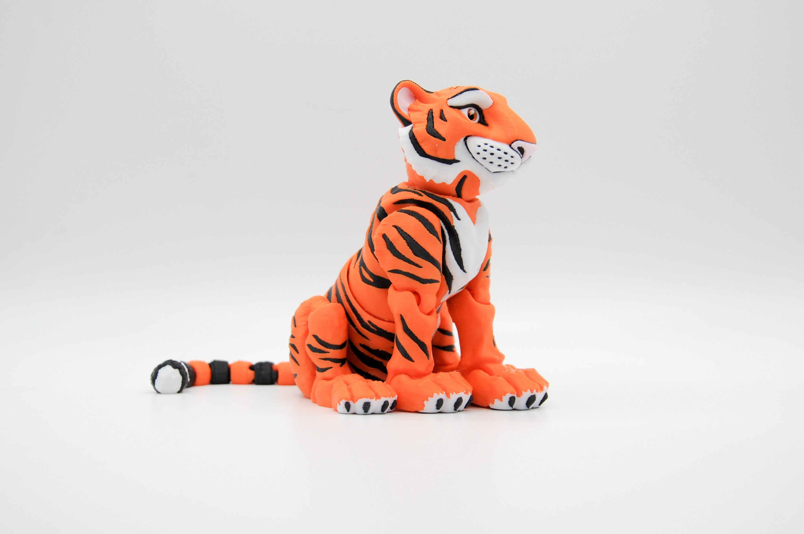Orange tiger figure with bold black stripes and long tail