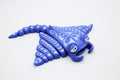 Blue manta ray figure with pale tribal-style patterns